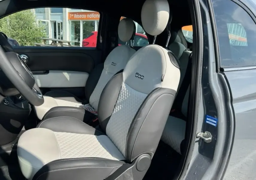 Vue intérieure côté conducteur de la FIAT 500C gris avec sellerie bicolore beige et noire au design matelassé.