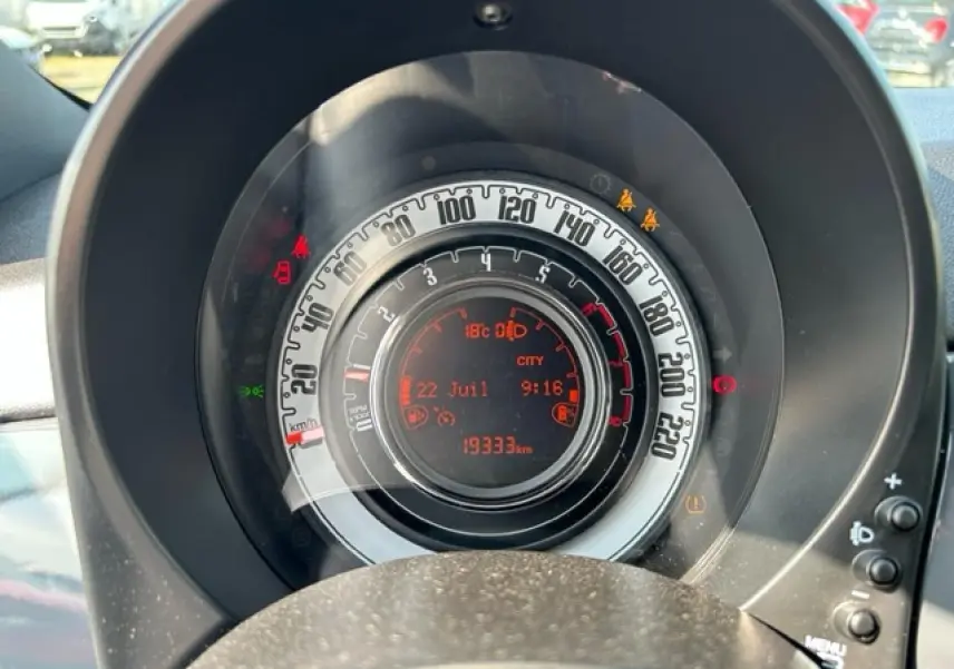 Gros plan sur le combiné de bord numérique TFT 7'' rouge et blanc du Fiat 500C gris/rouge de 2021.