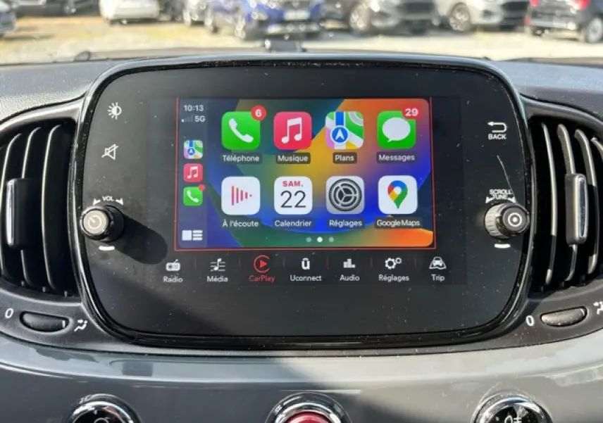 Écran tactile central avec interface Apple CarPlay dans le tableau de bord d'une Fiat 500C gris/rouge cabriolet.
