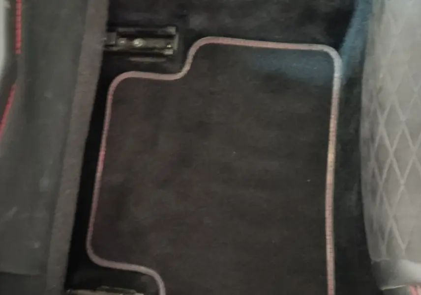 Vue rapprochée du tapis de sol noir avec surpiqûres rouges, côté arrière gauche du Renault Kadjar blanc Black Edition 2020.