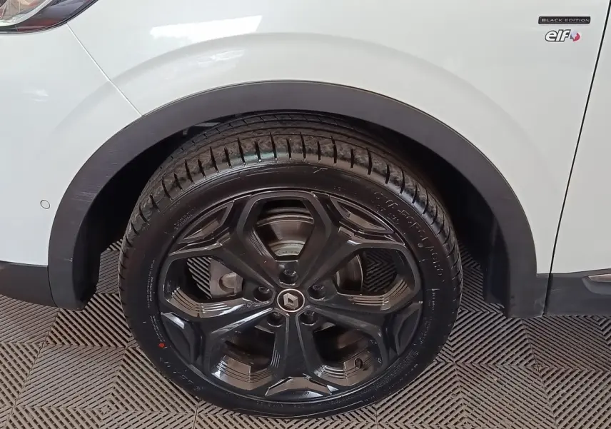 Gros plan sur la roue arrière droite noire et jante noire du Renault Kadjar blanc Black Edition.