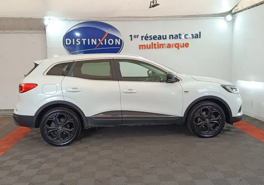 Profil droit d’un Renault Kadjar Blanc Black Edition 2020 avec jantes noires et détails chromés sous un éclairage intérieur.