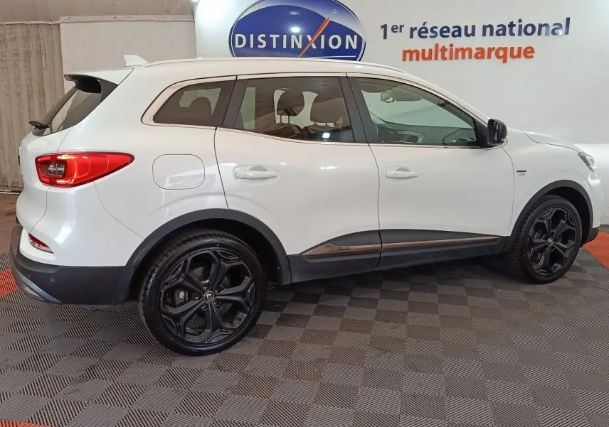 Vue de profil côté droit d’un Renault Kadjar blanc Black Edition avec jantes noires et détails chromés.