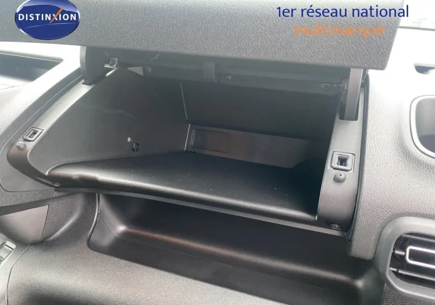 Vue intérieure du coffre à gants ouvert du Citroën Berlingo Fourgon blanc, montrant la console côté passager.