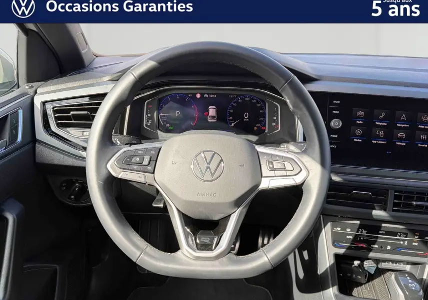 Vue intérieure centrée sur le volant cuir multifonctions et le tableau de bord digital du Volkswagen Taigo gris 2025.
