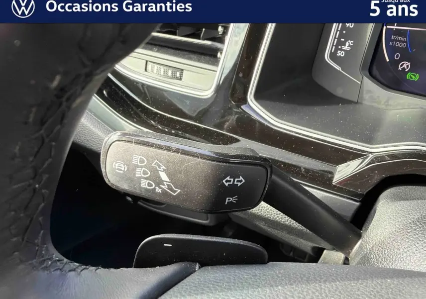 Gros plan sur la manette de clignotants noire et le tableau de bord digital du Volkswagen Taigo 2025.