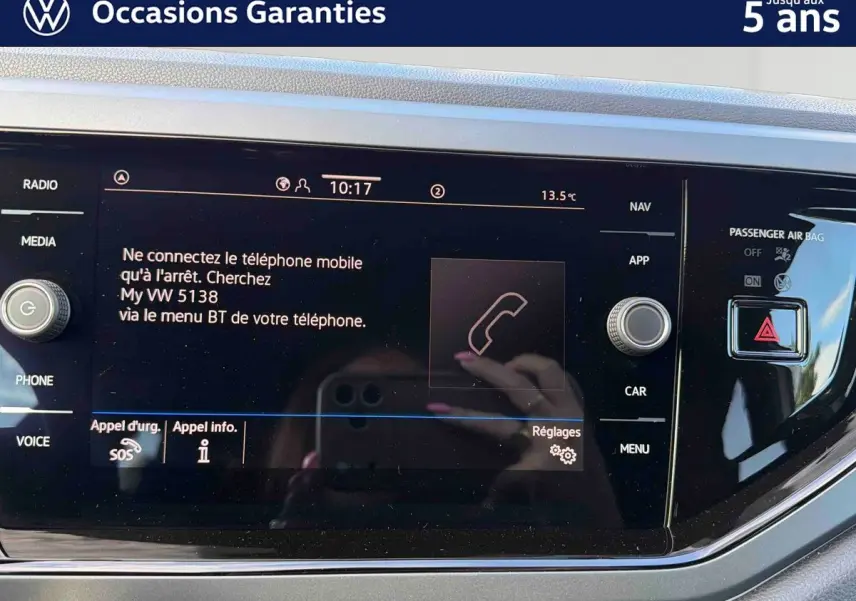 Écran tactile central du Volkswagen Taigo gris, affichant les options de connexion Bluetooth et commandes autour.