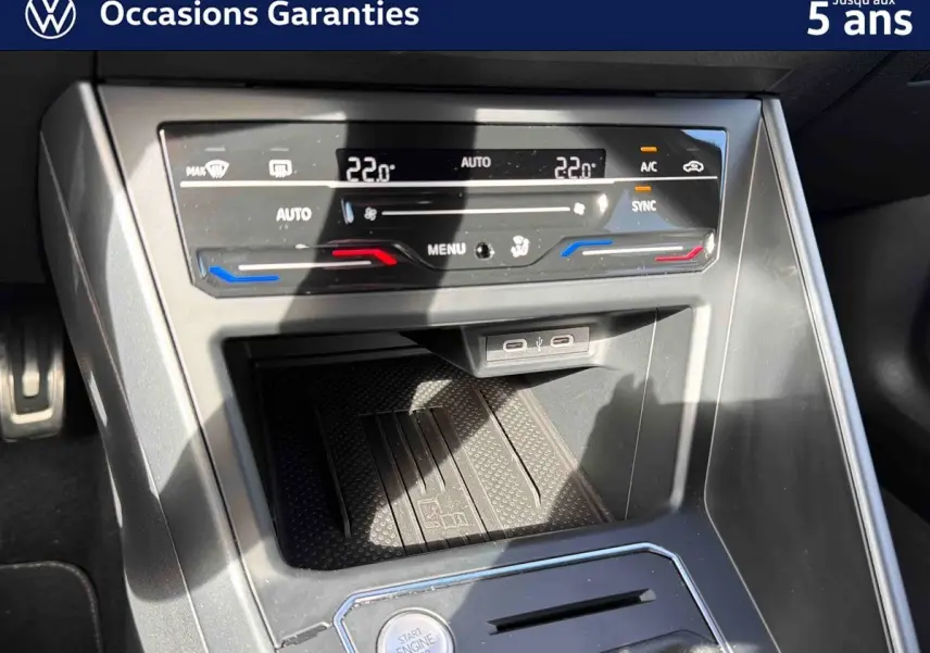 Vue rapprochée de la console centrale du Volkswagen Taigo gris, montrant les commandes de climatisation et le bouton start/stop.