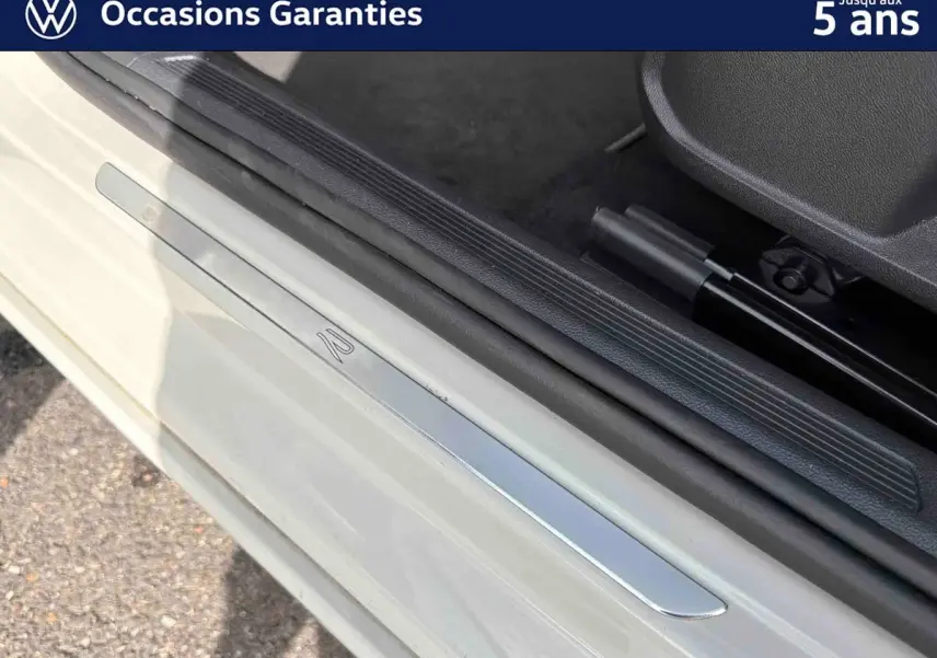 Seuil de porte côté conducteur gris clair avec insert métallique marqué du logo R sur un Volkswagen Taigo.