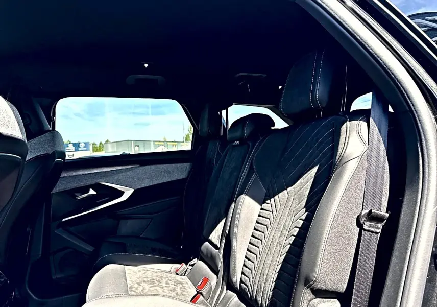 Vue intérieure côté droit des sièges arrière en tissu et cuir du Peugeot 5008 Hybrid 145 GT noir, avec ceinture visible.