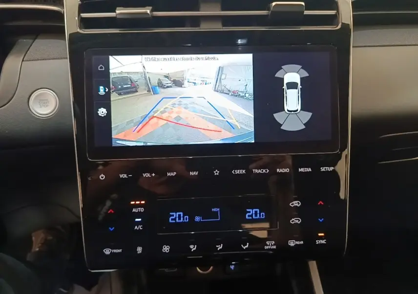 Vue rapprochée de l’écran tactile central du Hyundai Tucson bleu, affichant la caméra de recul et la climatisation digitale.