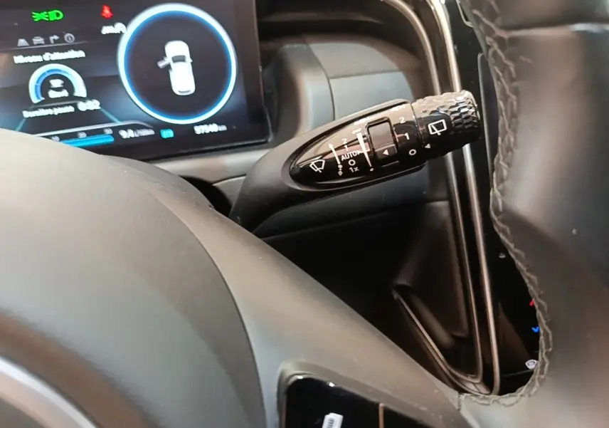 Gros plan sur la commande d’essuie-glace à droite du volant dans l’habitacle du Hyundai Tucson bleu 2021.