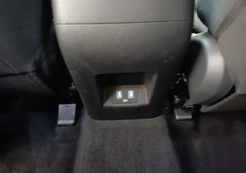 Vue rapprochée des ports USB arrière entre les sièges noirs du Hyundai Tucson bleu 2021.
