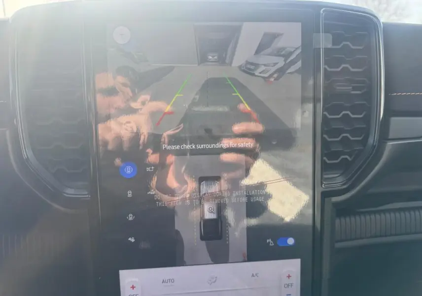 Écran tactile central du Ford Ranger gris 2025 montrant la caméra de recul avec commandes climatisation visibles.