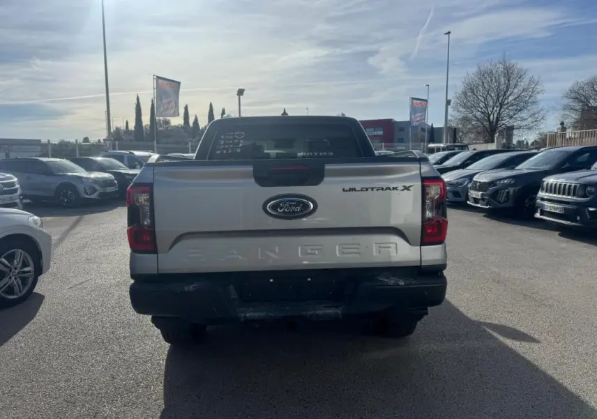 Vue arrière d'un Ford Ranger gris Wildtrak X avec hayon marqué Ranger et feux arrière rouges visibles.