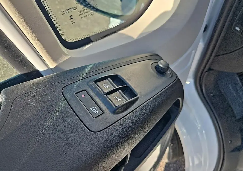 Gros plan sur les commandes des vitres électriques côté conducteur du Peugeot Boxer Fourgon blanc, porte ouverte.
