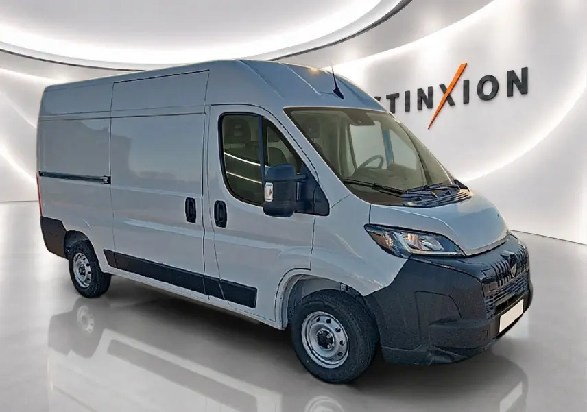Peugeot Boxer Fourgon blanc vu en 3/4 avant droit, porte latérale coulissante et pare-chocs noir visible.