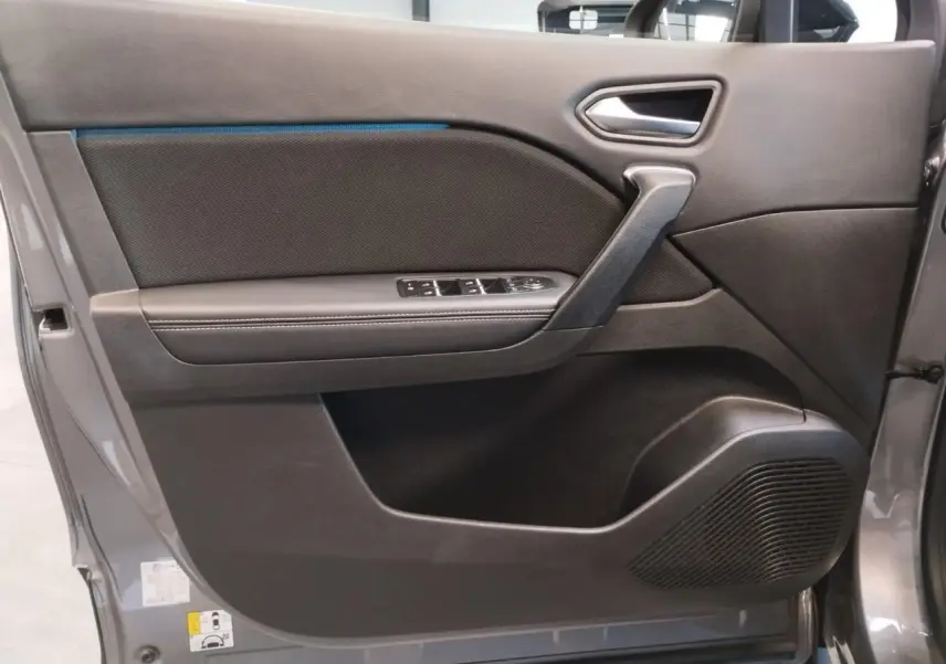 Porte avant gauche ouverte du Renault Symbioz 2025 gris Cassiopée, avec panneau noir et commandes de vitres intégrées.