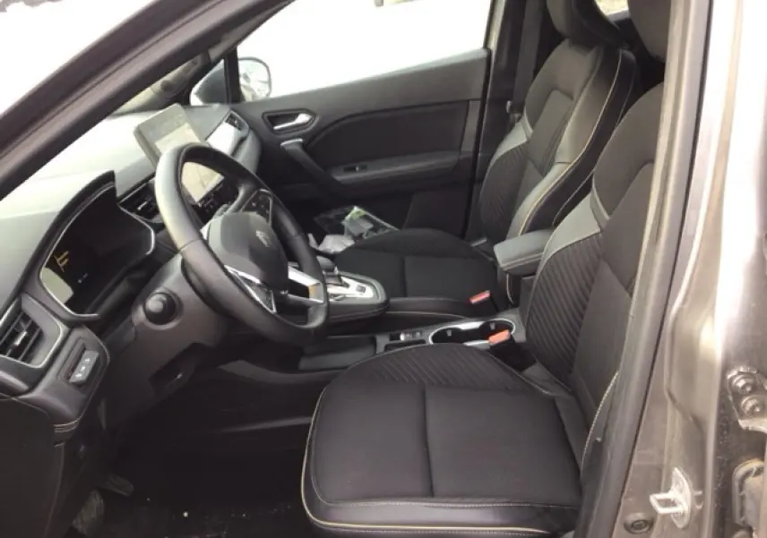 Vue intérieure côté conducteur du Renault Symbioz 2025, sièges noirs avec surpiqûres contrastées et tableau de bord moderne.