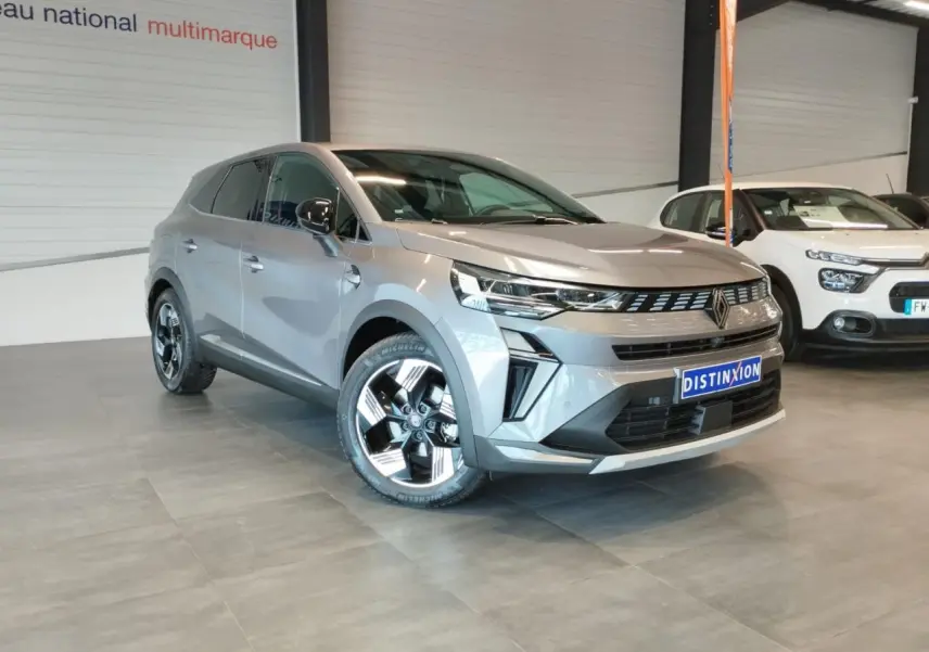 Renault Symbioz gris Cassiopée en 3/4 avant droit, avec jantes alliage 18 pouces et calandre noire distinctive.