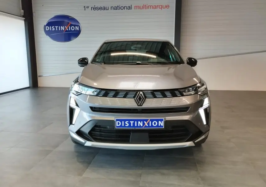 Vue frontale du Renault SYMBIOZ gris Cassiopée avec calandre noire et éclairage LED distinctif en intérieur showroom.
