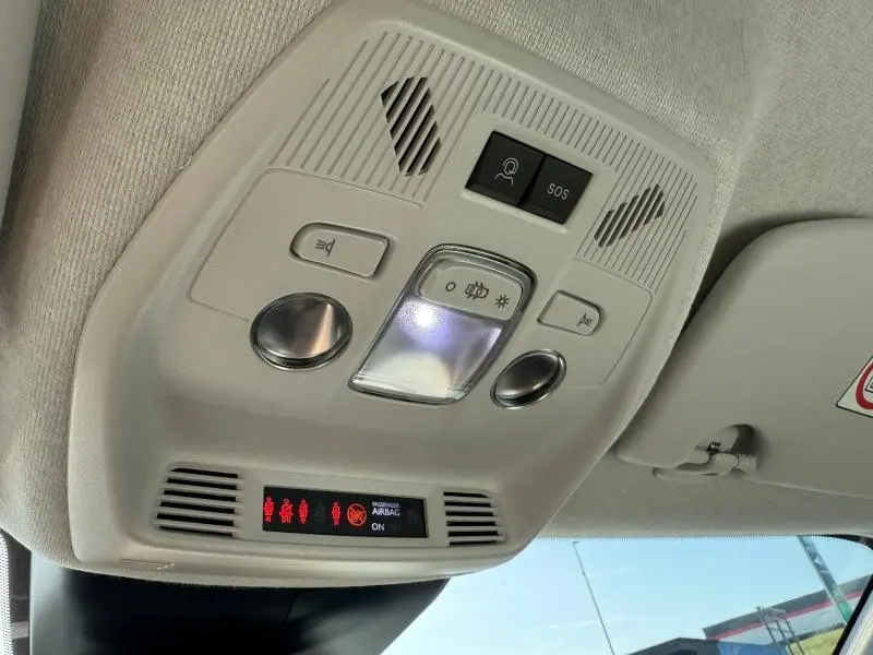 Vue en contre-plongée du plafonnier intérieur gris clair de la Citroën C3 électrique 2025 avec commandes lumineuses et SOS.