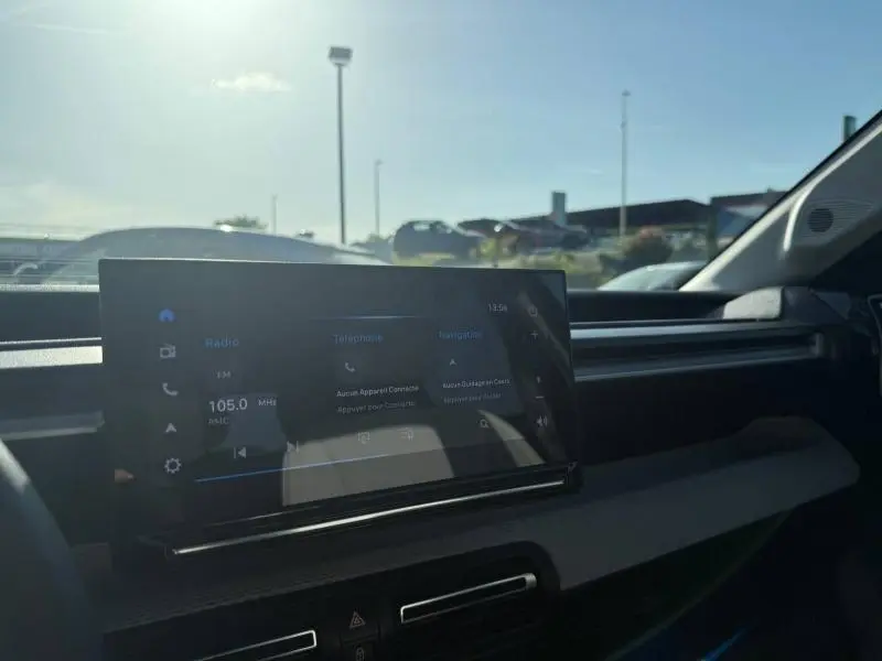 Vue intérieure du tableau de bord de la Citroën C3 électrique 2025, écran tactile multifonction avec interface sombre.