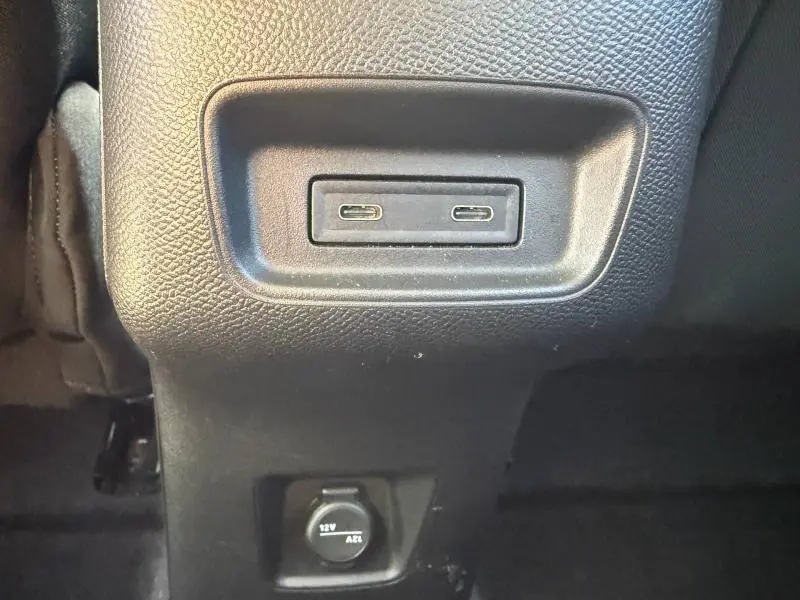 Vue rapprochée des ports USB-C et prise 12V noirs situés à l'arrière de la console centrale d'une Citroën C3 électrique 2025.