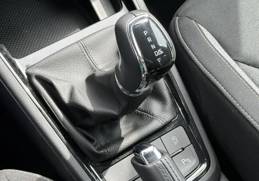 Gros plan sur le levier de vitesses automatique noir et chrome de la Skoda Scala TSI 116 DSG7, avec coutures visibles.