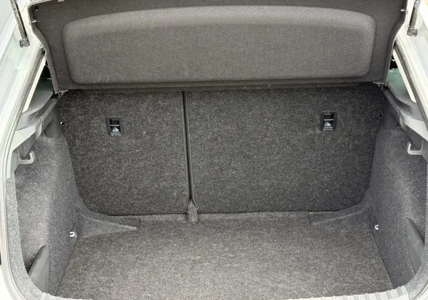 Coffre ouvert de la Skoda Scala TSI 116 DSG7 gris Reflex, montrant l'espace de chargement intérieur vide.