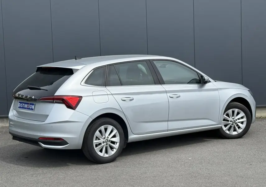 Vue 3/4 arrière droite d'une Skoda Scala gris Reflex avec vitres arrière surteintées et jantes alliage 16 pouces.