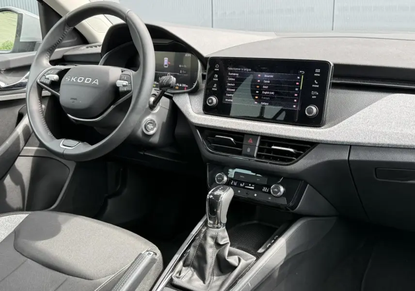 Intérieur de la Skoda Scala TSI 116 DSG7, vue côté conducteur, tableau de bord gris clair avec écran tactile 8,25 pouces.