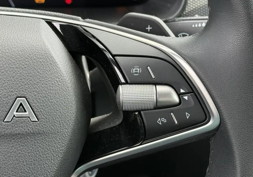 Gros plan sur les commandes multifonctions à droite du volant en cuir noir de la Skoda Scala TSI 116 DSG7 Sélection.