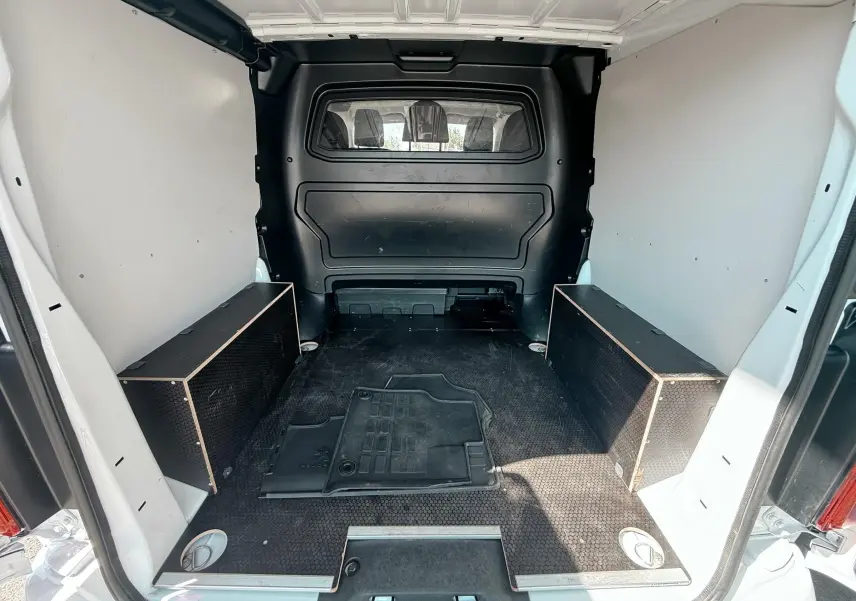 Vue intérieure arrière du coffre blanc du Peugeot Expert Cabine Approfondie avec plancher noir et rangements latéraux.