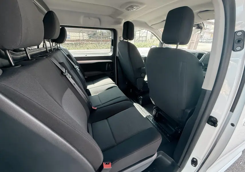 Vue intérieure côté droit du Peugeot Expert cabine approfondie blanc, montrant les sièges arrière en tissu gris noir.