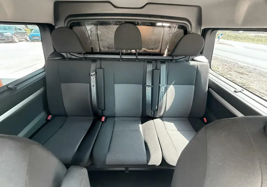 Vue intérieure arrière du Peugeot Expert cabine approfondie 2022, sièges tissu gris noir avec ceintures de sécurité visibles.