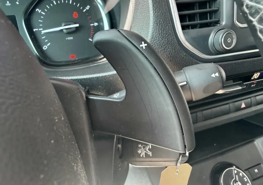 Gros plan sur la palette de changement de vitesses côté droit du tableau de bord noir du Peugeot Expert blanc.