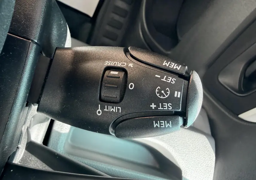 Gros plan sur la commande de régulateur de vitesse noire dans l'habitacle du Peugeot Expert cabine approfondie blanc.