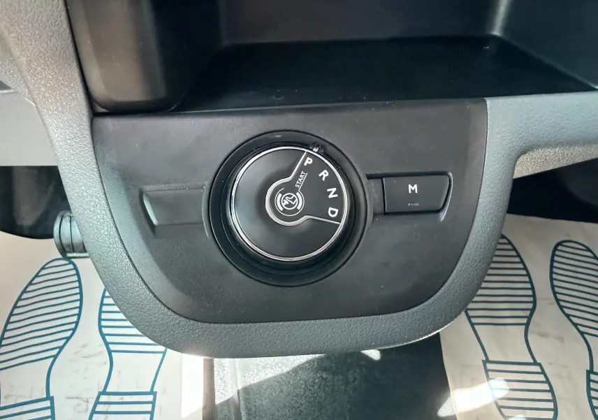 Gros plan sur la molette de sélection de la boîte automatique noire dans l'habitacle du Peugeot Expert cabine approfondie blanc.