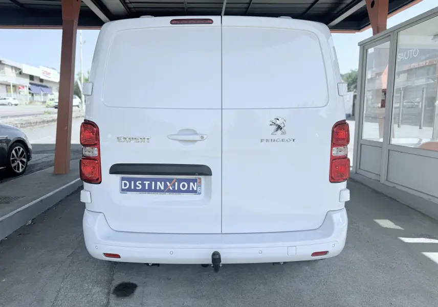 Vue arrière d’un Peugeot Expert cabine approfondie blanc avec logo et plaque d’immatriculation Distinxion visible.