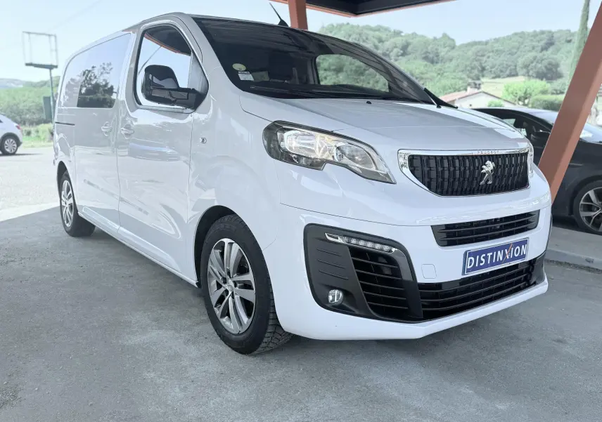 Peugeot Expert cabine approfondie blanc vu en 3/4 avant droit sous abri avec jantes alliage et calandre noire.