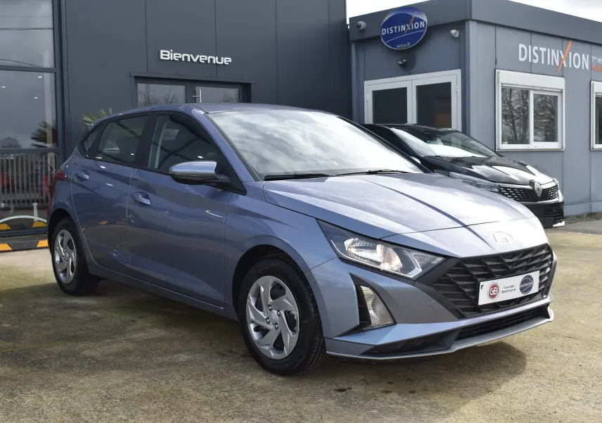 Vue 3/4 avant gauche d'une Hyundai i20 1.2 79 Intuitive bleu clair avec calandre noire et jantes alliage.