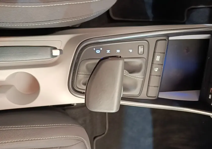 Vue rapprochée de la console centrale de la Hyundai Bayon 2024, levier de vitesse automatique en cuir gris.