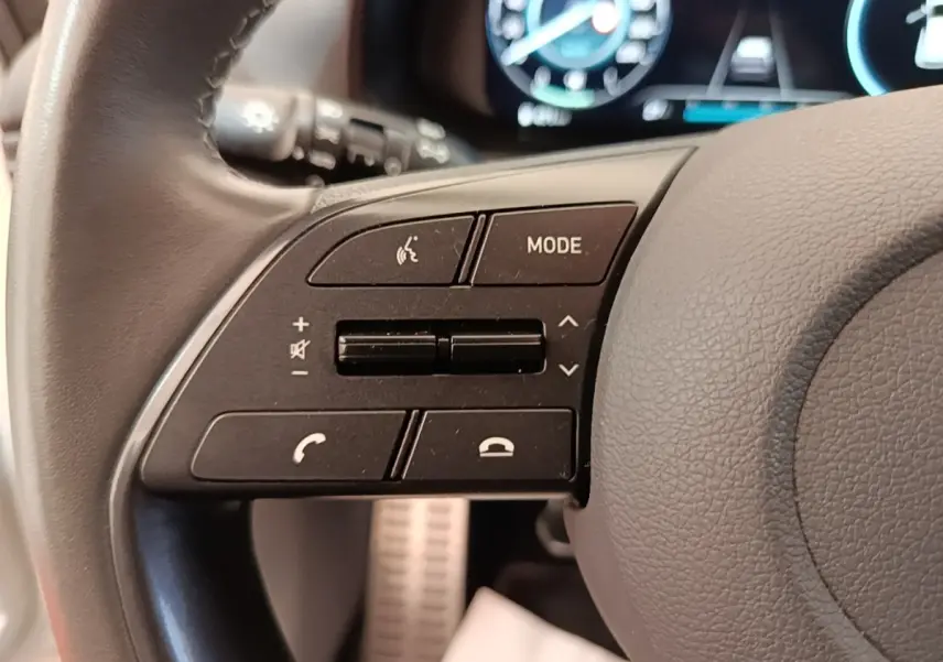 Gros plan sur les commandes gauche du volant cuir du Hyundai Bayon 2024, avec affichage numérique en arrière-plan.