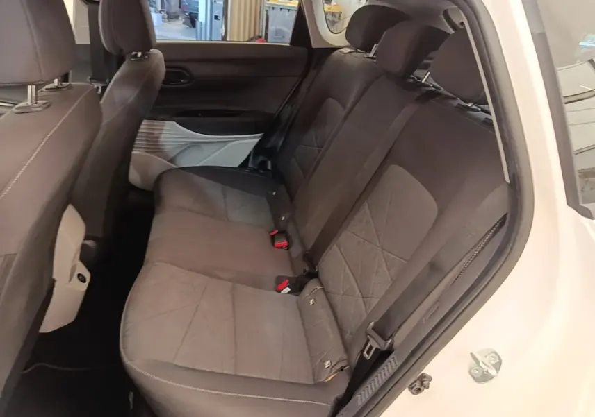 Vue intérieure côté droit des sièges arrière gris foncé d'un Hyundai Bayon blanc, avec ceinture et porte ouvert.