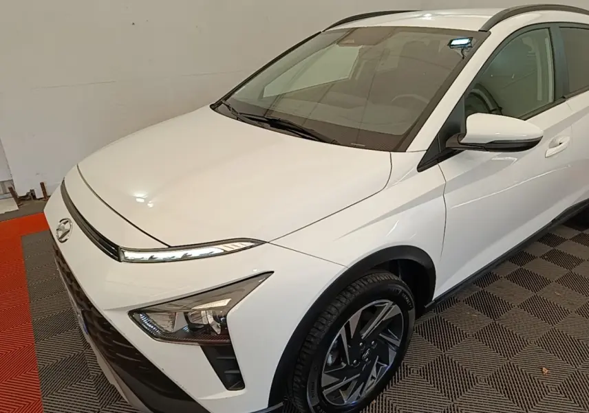 Vue 3/4 avant droit d'une Hyundai Bayon blanche 2024 avec phares LED et jantes alliage noires.