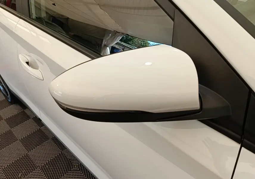 Rétroviseur blanc côté conducteur de Hyundai Bayon 2024, avec clignotant intégré et carrosserie blanche visible.