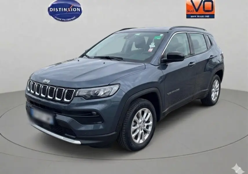 Jeep Compass bleu en vue 3/4 avant droit, avec jantes alliage 18 pouces et calandre distinctive à sept ouvertures.