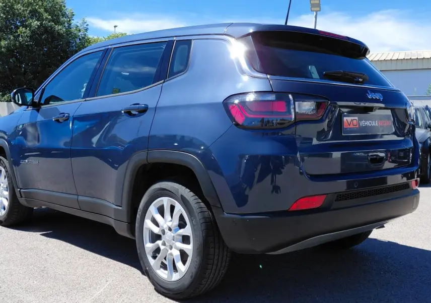 Jeep Compass bleu 3/4 arrière droit, jantes alliage 18 pouces, feux arrière LED et vitres teintées.