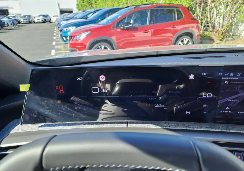 Vue intérieure du tableau de bord numérique du Peugeot 3008 gris Artense, affichant la vitesse et la navigation.